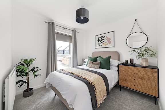 A bedroom with a bed, a plant, and a hanging mirror at The Woodlands Apartments, Milton Keynes, MK5 6GS