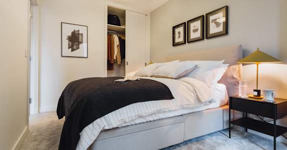Floor Plan  A bedroom with a bed, a nightstand with a lamp, and a wardrobe.at Slate Yard Apartments, Salford