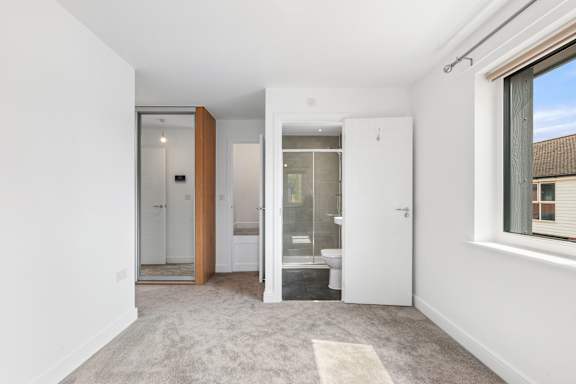 A white room with a rug and a glass door.