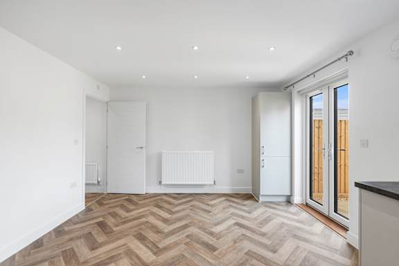A room with a chevron patterned floor and white walls.