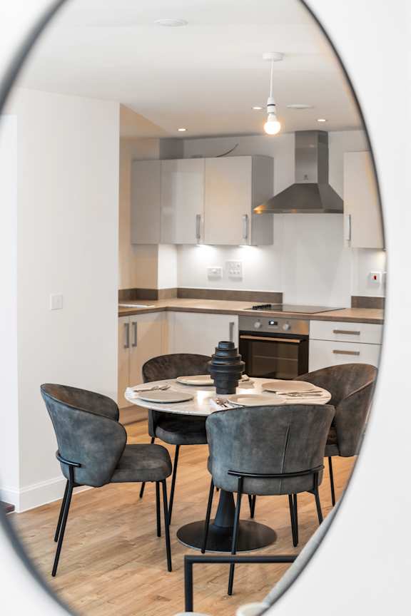 A modern kitchen with a round table and chairs.