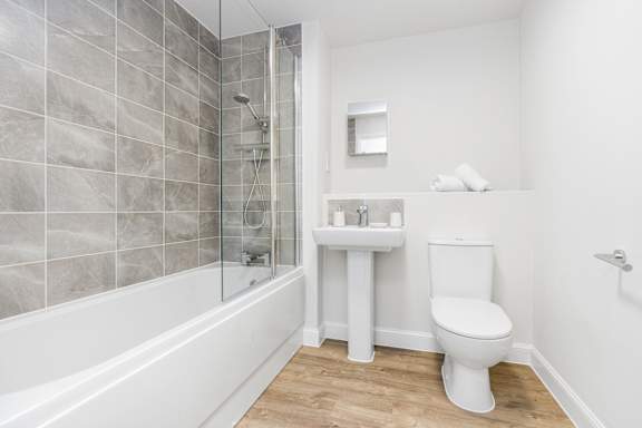 A white toilet sits next to a sink in a bathroom.