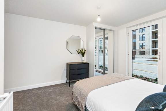 A bedroom with a bed, dresser, and mirror.