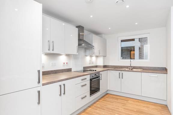 A modern kitchen with white cabinets and stainless steel appliances.