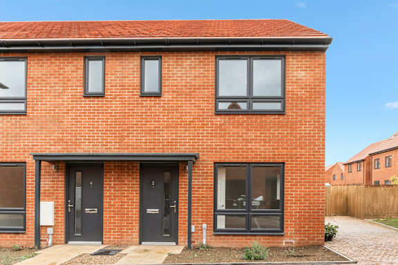 A red brick house with a black front door.