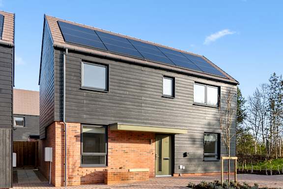A modern house with solar panels on the roof.