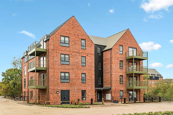 A red brick building with balconies on the second floor.