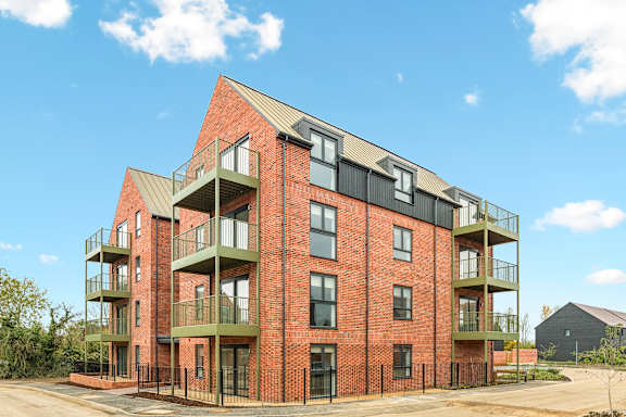 A red brick building with balconies on the second floor.