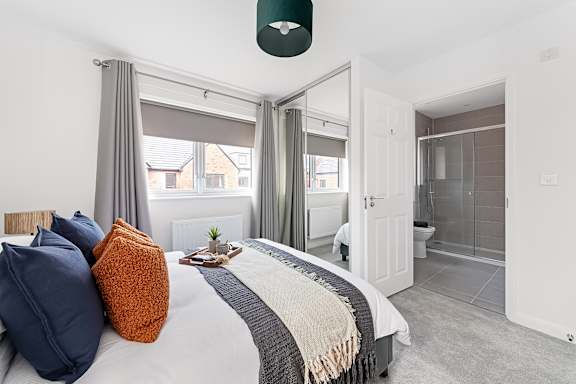 A bedroom with a large bed and a window with curtains at The Woodlands Apartments, Milton Keynes, MK5 6GS