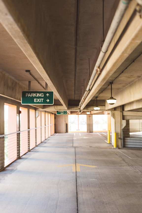 A parking garage with a sign that says "Parking Exit" and a yellow arrow pointing to the right.