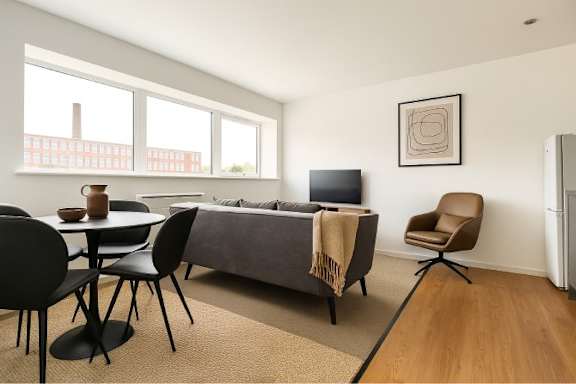 A living room with a grey couch, a brown chair, and a television.