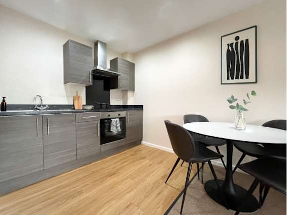 A modern kitchen with a dining table and chairs.