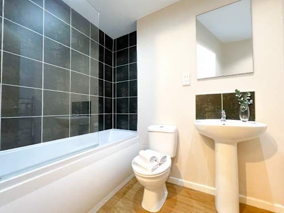 A white toilet sits next to a sink in a bathroom.