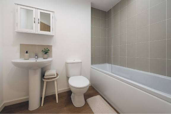 A white bathroom with a toilet, sink, and bathtub.