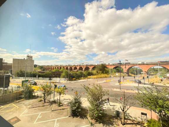 A view of a roundabout with a bridge in the background.