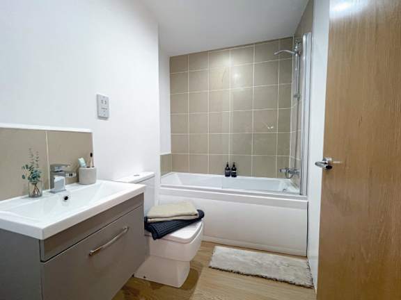 A white bathroom with a toilet, sink, and bathtub.