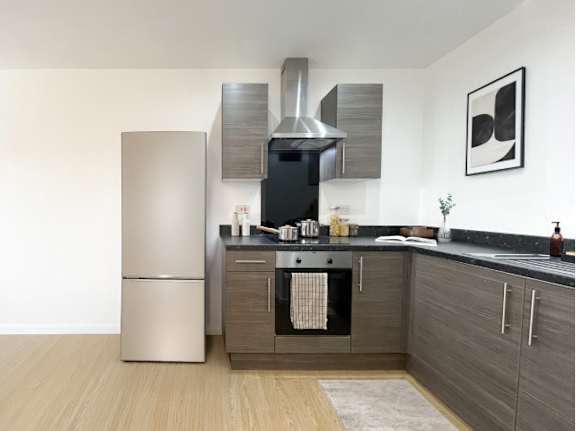 A modern kitchen with a stainless steel refrigerator and a black oven.
