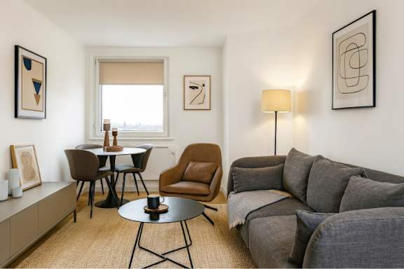 A living room with a grey couch, a brown chair, and a black table.