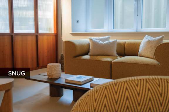 A living room with a sofa, armchair, and a coffee table.