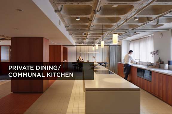 A modern kitchen with a long counter and a man in the background.