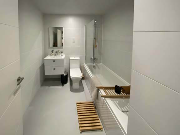 A white bathroom with a toilet, sink, and mirror.