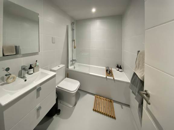 A white bathroom with a toilet, sink, and bathtub.