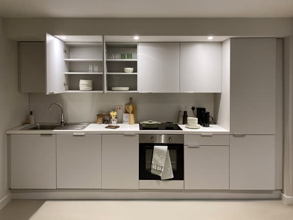 A modern kitchen with white cabinets and appliances.