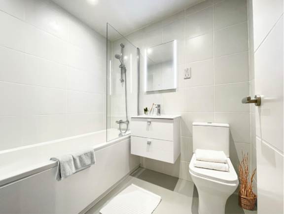 A white bathroom with a toilet, sink, and bathtub.