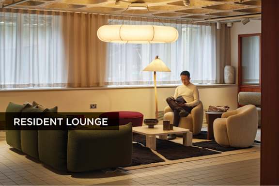 A man is sitting on a chair in a resident lounge.
