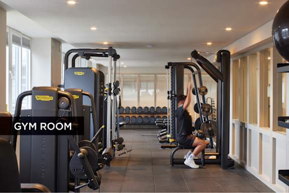 A woman is working out in a gym with a variety of equipment.