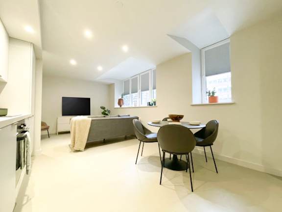 A modern kitchen with a dining table and chairs.