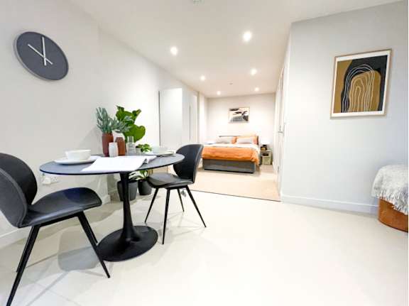 A modern dining area with a round table and chairs.