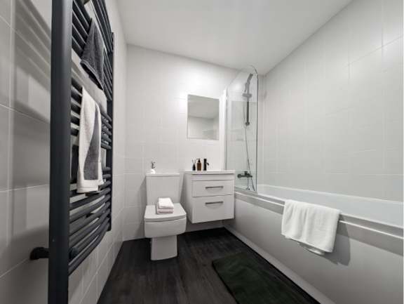 A white toilet sits next to a white sink in a bathroom.
