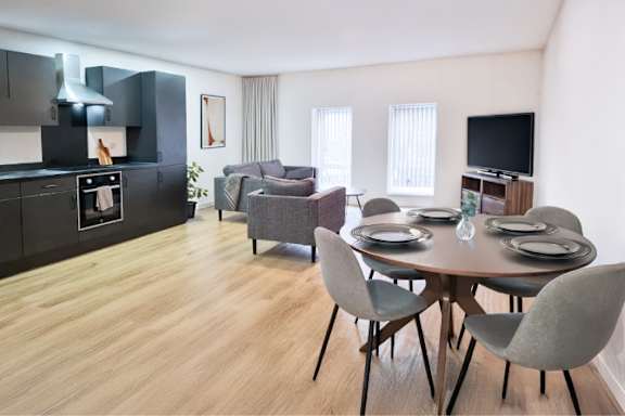 A modern kitchen with a dining table set for four.