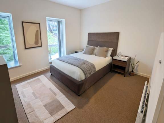 A bedroom with a large bed and a window.