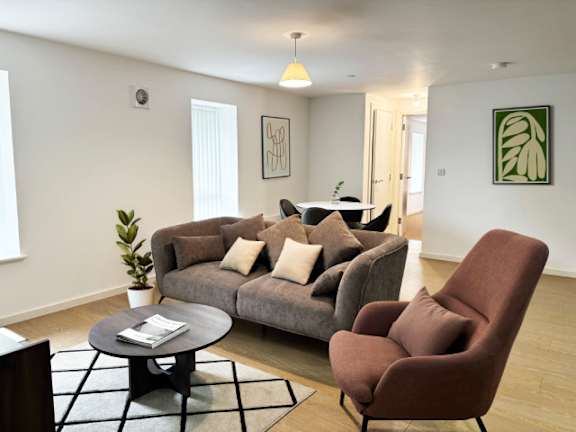 A living room with a grey couch, a brown chair, and a coffee table.