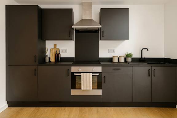 A modern kitchen with dark brown cabinets and a stainless steel range hood.