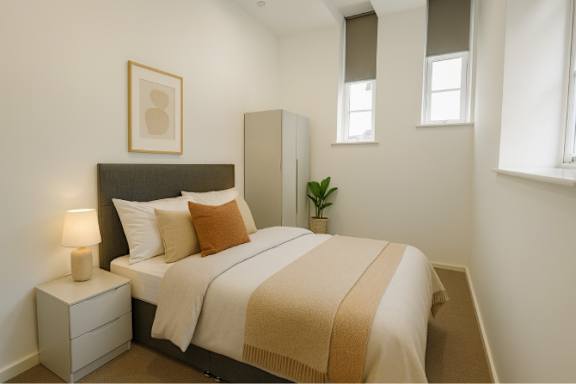 A bedroom with a bed, nightstand, and lamp.