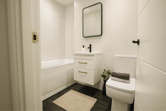A white bathroom with a toilet, sink, and bathtub.