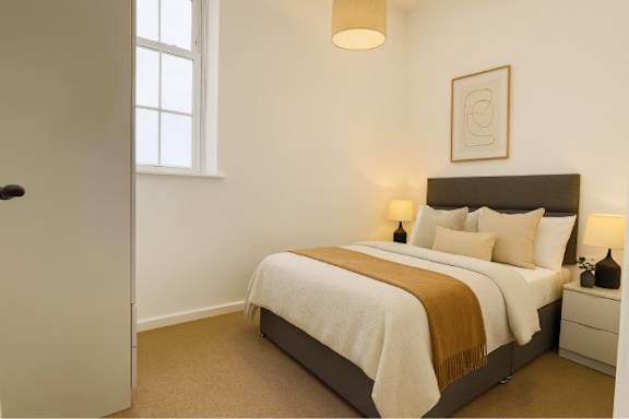 A bedroom with a large bed and a window.