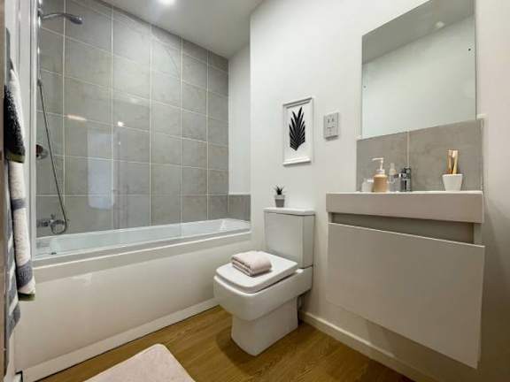 A white toilet sits next to a bathtub in a bathroom.