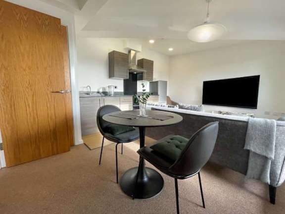 A modern dining area with a round table and two chairs.