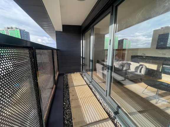 A balcony with a mesh screen and a table and chairs.