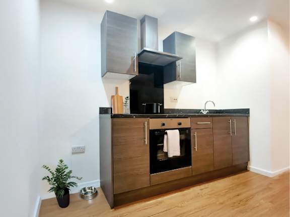 A modern kitchen with wooden cabinets and a black countertop.