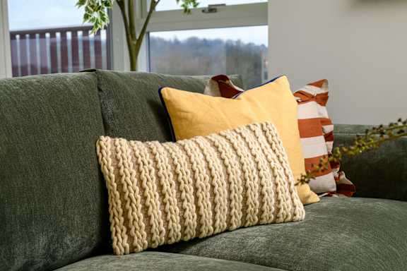 A couch with a yellow pillow and a striped pillow on it.