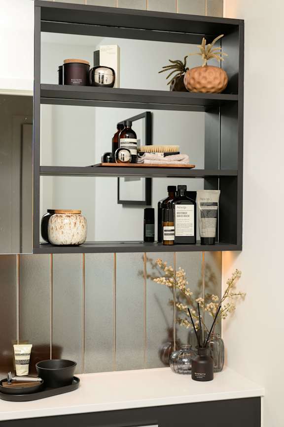A shelf with various items including a pineapple, candles, and bottles.
