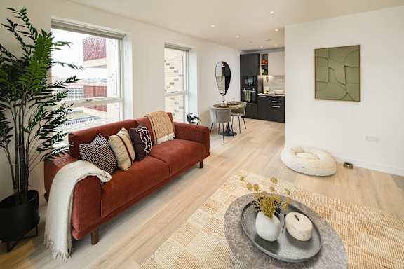 A living room with a red couch and a rug.