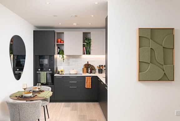 A modern kitchen with a dining table set for two.
