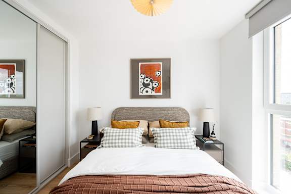 A bedroom with a large bed and two lamps.