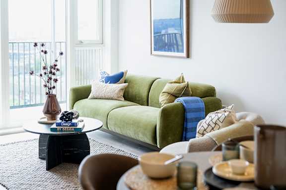 A living room with a green couch and a coffee table.